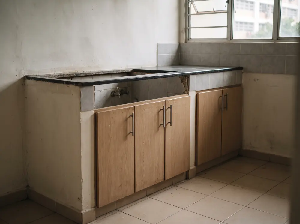A row of kitchen base carpentry units under a bare countertop cutout