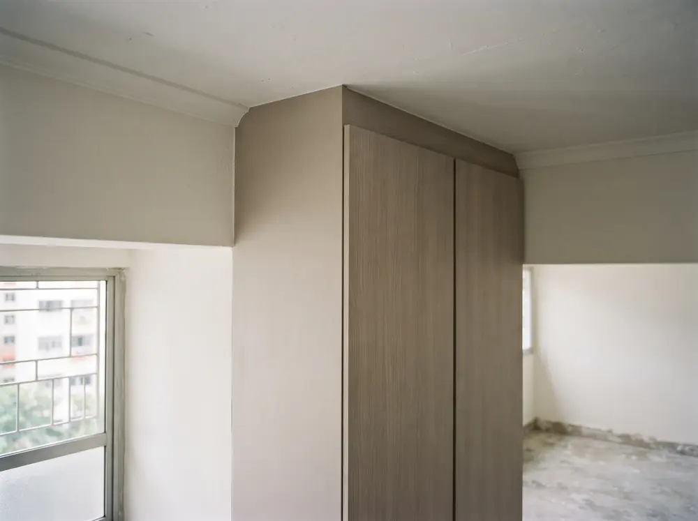 A tall carpentry unit meeting a ceiling with a filler strip