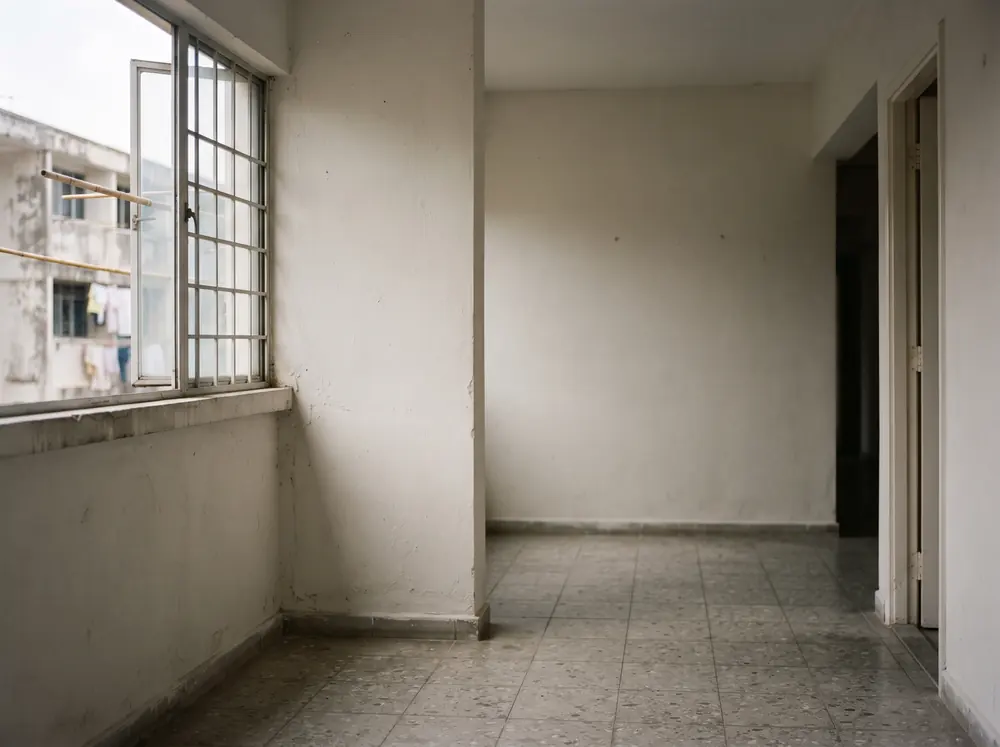 An empty apartment room with window light on bare walls