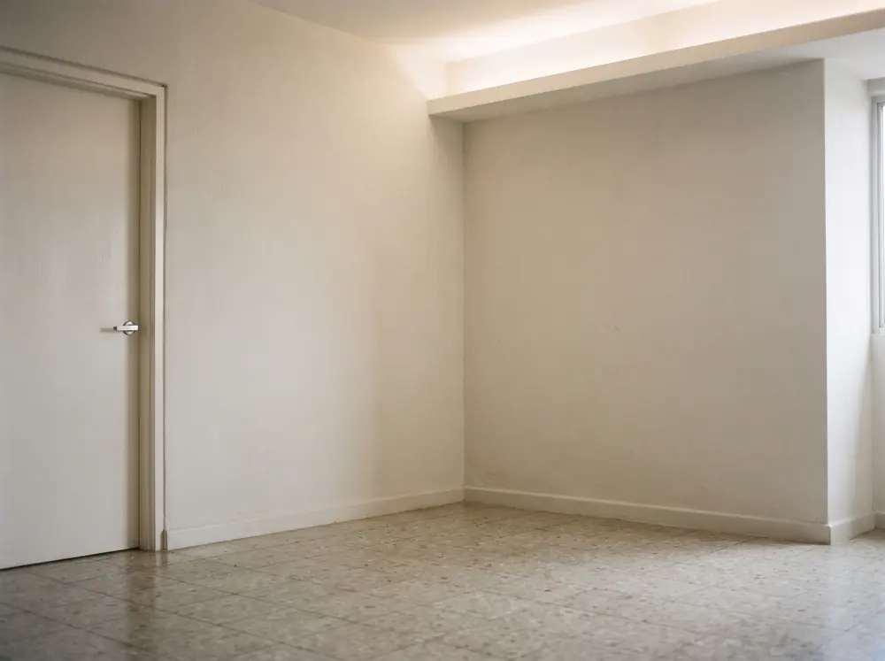 A bare room corner lit softly from a concealed cove
