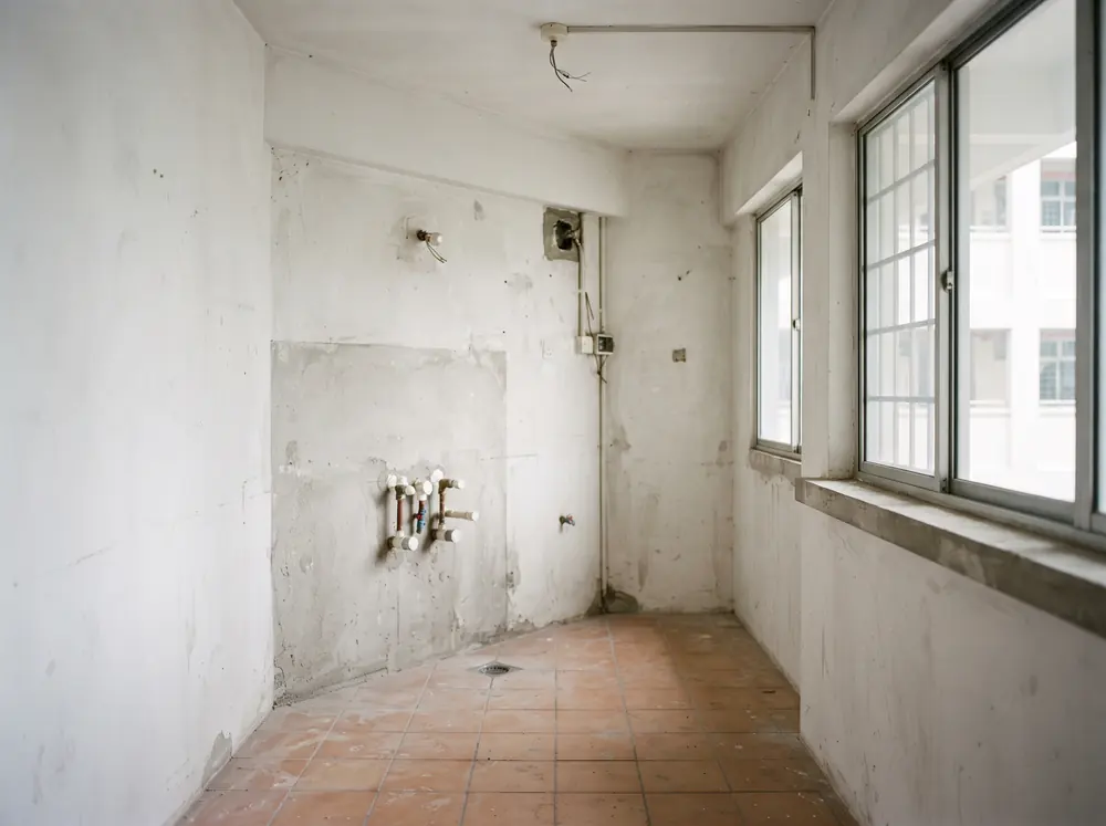 A bare kitchen shell with capped services and no fittings